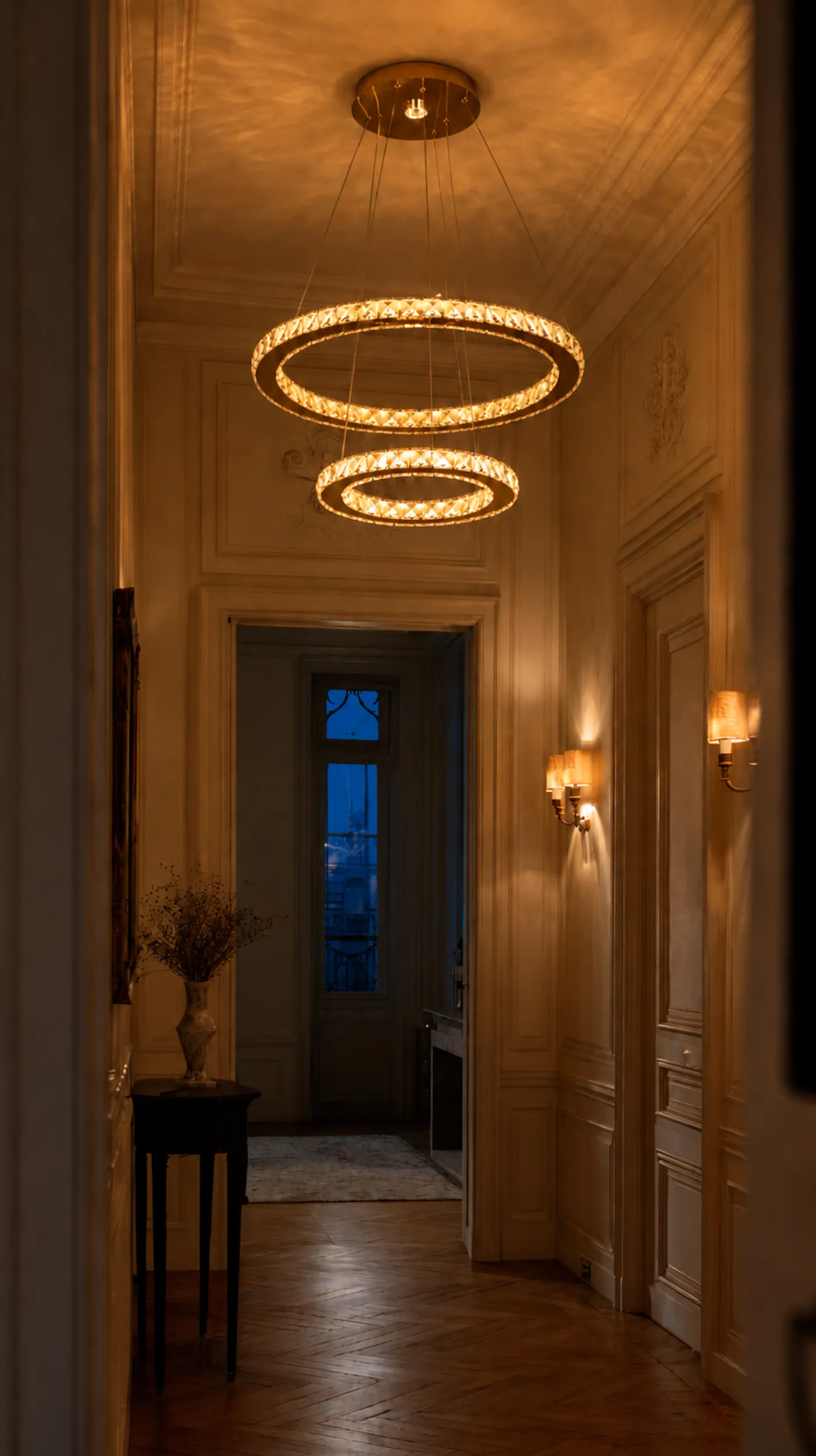 Suspension dorée en cristal Le Céleste dans un salon parisien chaleureux.